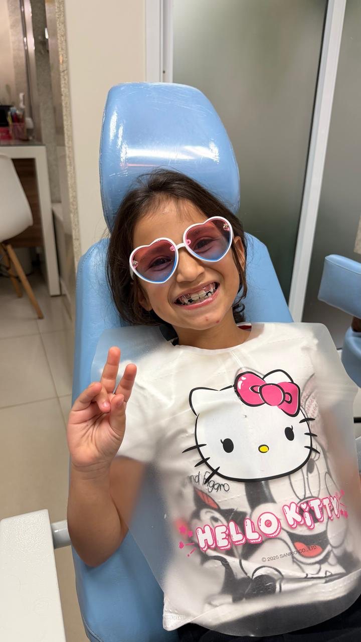 Paciente sorrindo na cadeira do consultório